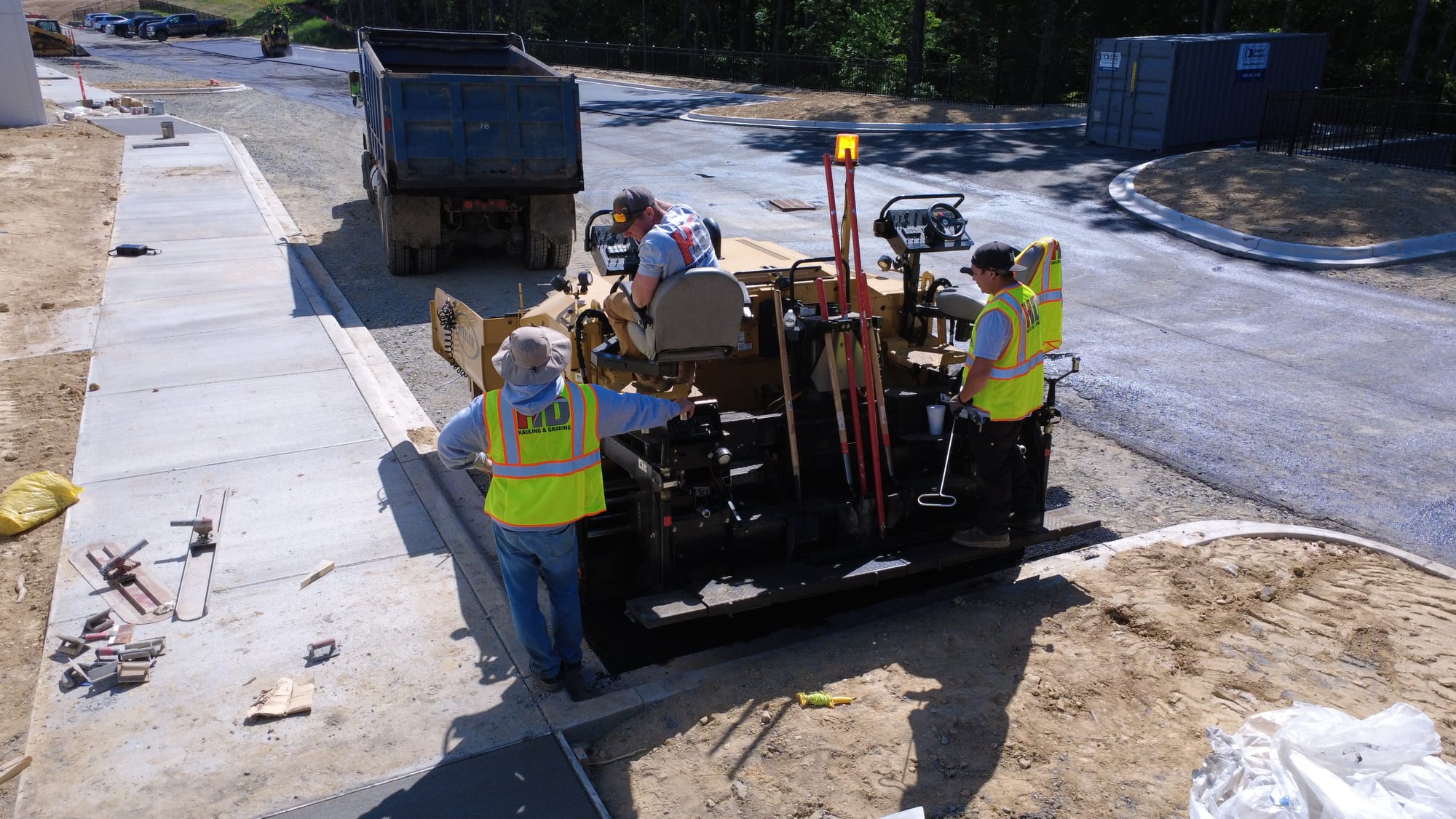 HD Grading crew operating an asphalt paver on an active job site